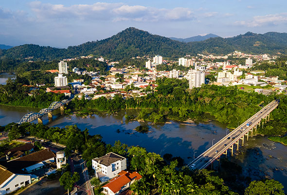 Fotografia aérea da cidade de Indaial, mostrando as pontes sobre o rio.
