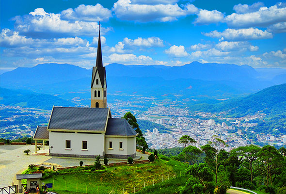 Fotografia da cidade de Jaraguá do Sul. À frente, está a Chiesetta Alpina, no alto do Morro Boa Vista.