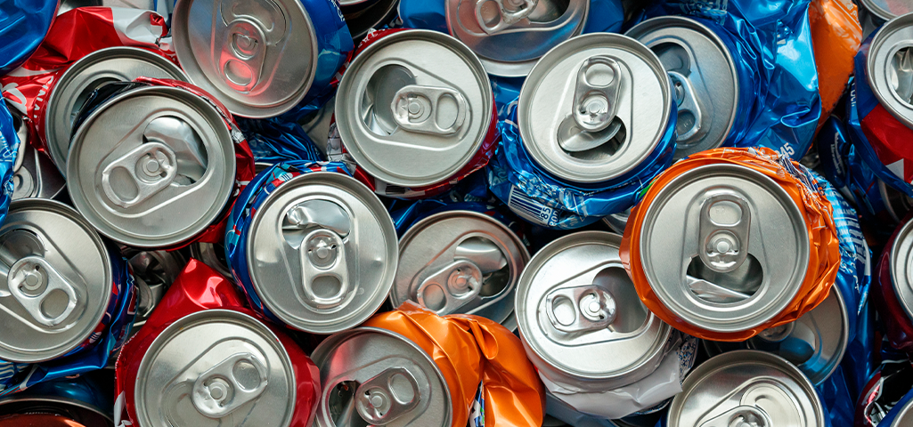 Imagem de várias latas de refrigerante amassadas.