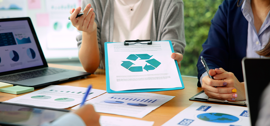 Pessoa segurando papel com símbolo da reciclagem.